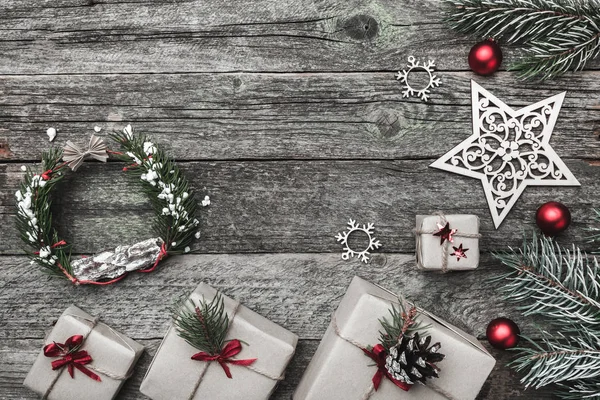 Üst, üst, görüntülemek üzerinden yukarıda beyaz kış figürinler, herdem yeşil dal, kırmızı oyuncak, hediyeler ve yazma, tebrik metin için yer ile gri arka plan üzerinde mutlu Noeller yazıt