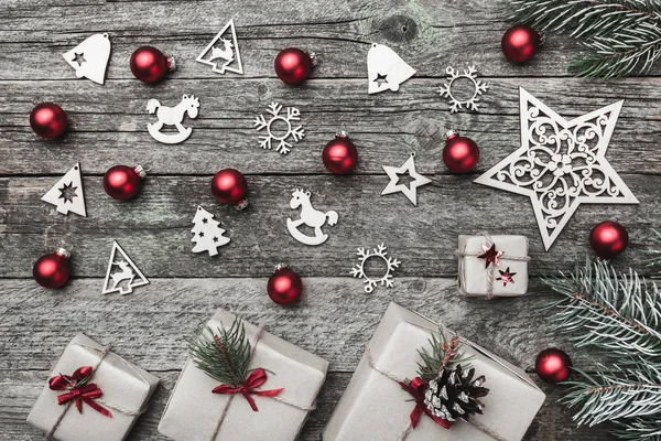 Üst, üst, görüntülemek üzerinden yukarıda beyaz kış figürinler, yaprak dökmeyen şube, kırmızı oyuncak, hediyeler ve gri arka plan, kitabe Merry Christmas tebrik