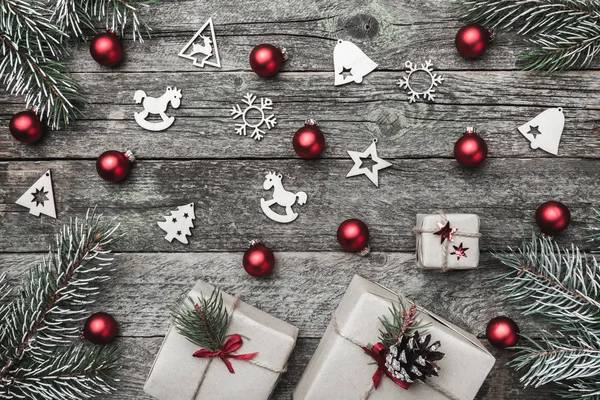 Üst, üst, görüntülemek üzerinden yukarıda beyaz kış figürinler, yaprak dökmeyen şube, kırmızı oyuncak, hediyeler ve gri arka plan, kitabe Merry Christmas tebrik