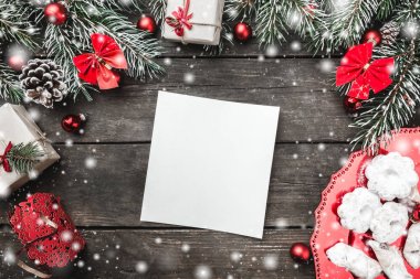 Noel Tema çam dalları, koniler, kırmızı yay ve Küre, mevcut kutuları ve şekerler, tanımlama bilgileri ile not etmek için ahşap arka plan üzerinde metin yukarıdan, karda, tebrik kartı izlendi 
