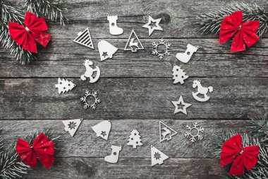 Dört çam dalları kırmızı ok ve xmas el yapımı oyuncak bir daire ahşap gri bir arka plan, metin, Noel tebrik kartı için yer ile oluşturma