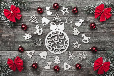 Dört çam dalları kırmızı ok ve xmas el yapımı oyuncak bir daire ahşap gri bir arka plan üzerinde Noel tebrik kartı oluşturma