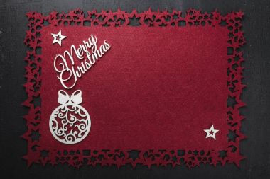 Neşeli Noel Yazıt kırmızı kumaş arka plan ve ahşap el yapımı Küre ve yıldız, yukarıdaki metin yazmak için boş alan ile görüntüleme. 