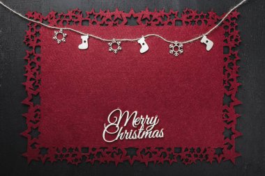 Bazı ile neşeli Noel Yazıt kırmızı kumaş arka plan üzerinde bir ip asılı el yapımı ahşap oyuncaklar görüntülemek yukarıdan, metin yazmak için boş alan ile. 