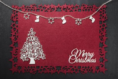 Bazı ile neşeli Noel Yazıt kırmızı kumaş arka plan üzerinde bir ip asılı el yapımı ahşap oyuncaklar görüntülemek yukarıdan, metin yazmak için boş alan ile. 