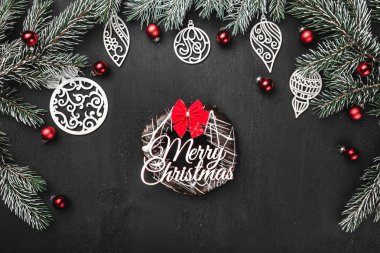 Üst, üst, görüntülemek üzerinden yukarıda, çörek, el yapımı ahşap oyuncak, herdem yeşil dallar, tebrik kartı siyah zemin üzerine kırmızı Küre.