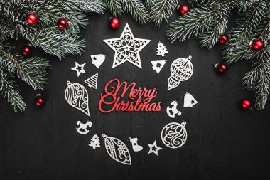 Üst, üst, görüntülemek yukarıdan, el yapımı ahşap oyuncaklar çemberi yuvarlak şekli, herdem yeşil dallarda siyah arka plan ve bir Merry Christmas yazıt, tebrik.