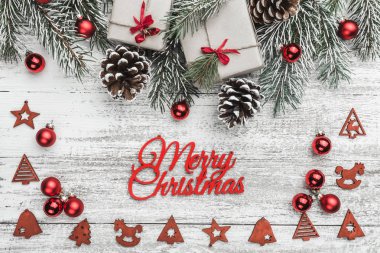 Yukarıdan görünüm, üst, köknar dalı pines, mevcut kutuları, kırmızı ağaç Küre, el yapımı ağaç oyuncaklar ve Merry Christmas yazıt, tebrik kartı ile bir beyaz ahşap tahta zemin üzerine