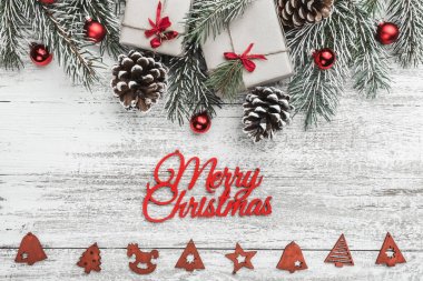 Yukarıdan görünüm, üst, köknar dalı pines, mevcut kutuları, kırmızı ağaç Küre, el yapımı ağaç oyuncaklar ve Merry Christmas yazıt, tebrik kartı ile bir beyaz ahşap tahta zemin üzerine
