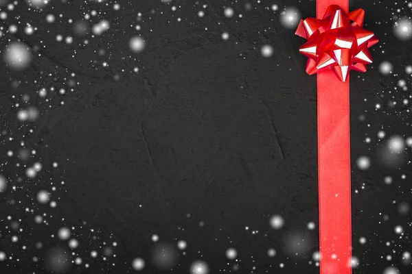 Red Ribbon Decorative Bow Black Stone Background Snow View Top — Stock Photo, Image