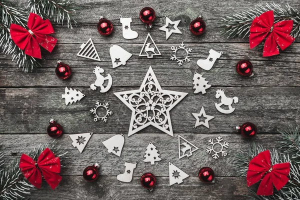Dört çam dalları kırmızı ok ve xmas el yapımı oyuncak bir daire ahşap gri bir arka plan üzerinde Noel tebrik kartı oluşturma
