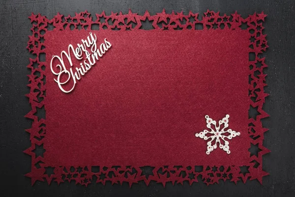 Neşeli Noel Yazıt kırmızı kumaş arka plan ve ahşap el yapımı yıldız, yukarıdaki metin yazmak için boş alan ile görüntüleme. 