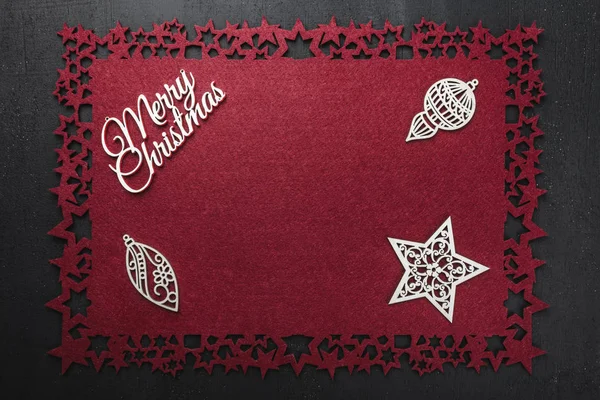 Neşeli Noel yazıt, bazı el yapımı ahşap oyuncaklar ve Star'da kırmızı kumaş arka plan, yukarıdaki metin yazmak için boş alan ile göster. 