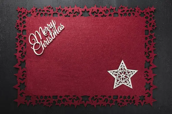 Neşeli Noel Yazıt kırmızı kumaş arka plan ve ahşap el yapımı yıldız, yukarıdaki metin yazmak için boş alan ile görüntüleme. 