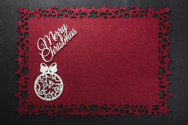 Neşeli Noel Yazıt kırmızı kumaş arka plan ve ahşap el yapımı Küre, yukarıdaki metin yazmak için boş alan ile görüntüleme. 