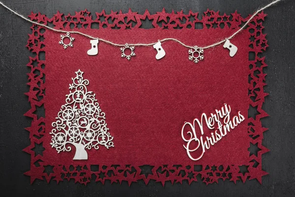 Bazı ile neşeli Noel Yazıt kırmızı kumaş arka plan üzerinde bir ip asılı el yapımı ahşap oyuncaklar görüntülemek yukarıdan, metin yazmak için boş alan ile. 