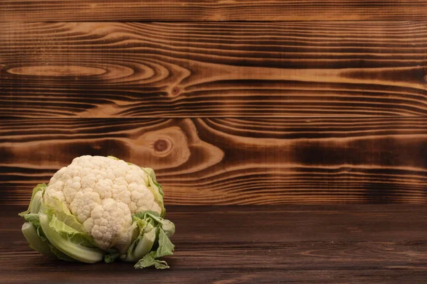 新鮮な野菜だ コピースペースのある木製のテーブルの上に緑の葉を持つ白いカリフラワー — ストック写真