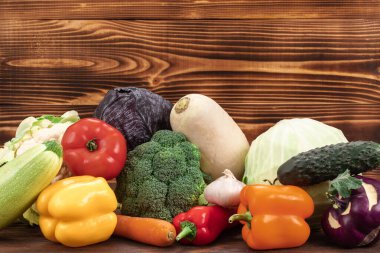 Kahverengi ahşap arka planda, fotokopi alanı olan çeşitli taze sebzeler. Yemek yapmak için sağlıklı yiyecekler.