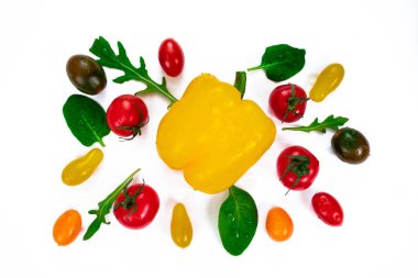 Farklı renklerde kiraz domatesleri, çan sarısı biberin etrafında roka yaprakları ve fesleğen. Beyaza izole edilmiş taze sebzeler ve otlar.