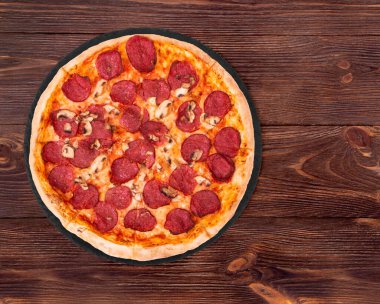 Tahta tabanlı mantarlı salamlı pizza, ahşap masa üstü manzaralı, metin için alan