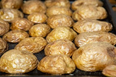 Tepside servis edilen kabuklu lezzetli pişmiş patatesler. Vejetaryen mutfağı