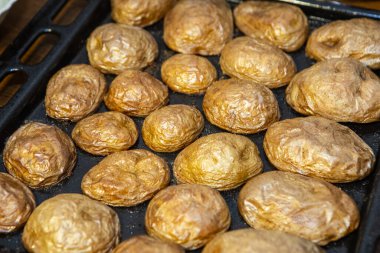 Fırından yeni çıkmış sıcak bir tabakta lezzetli altın fırında patateslerin arka planı.