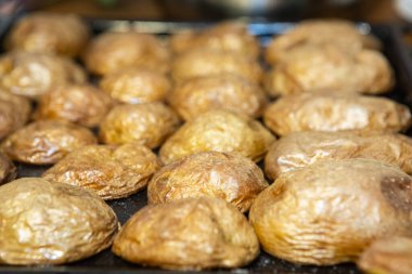 Fırınlanmamış patates parçaları sıcak bir tabakta, seçici bir odak noktası.