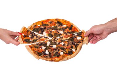 Bir erkek ve bir kadının elleri pizza dilimleri alır, bakış açısı. Mozarella, feta, vişneli domates, ıspanak, mantar ve kalamata zeytinli lezzetli pizza.
