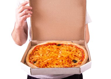 Genç bir adam pizza kutusunu açıyor, pizza servisi. Mozarella, bocconcini ve fesleğen yapraklı lezzetli taze pizza veya pizza margherita. 