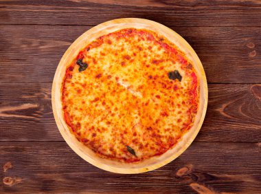 Mozzarella, bocconcini ve fesleğen yapraklı tam lezzetli pizza ya da ahşap ahşap bir tabakta pizza margherita.