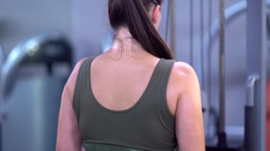 Bir kız kollarının kaslarını güçlendirmek için spor egzersizleri yapar..