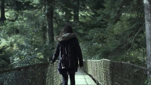 Uma Viajante Fêmea Cruza Uma Ponte Feita Cordas Tábuas Madeira — Vídeo de Stock