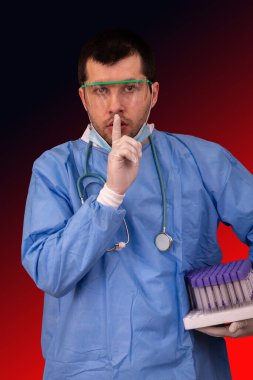 Gözlüklü, maskeli, stereoskoplu doktor elinde tüplerle Covid-19 ya da Coronavirus araştırma laboratuvarında sessiz olmak istiyor.
