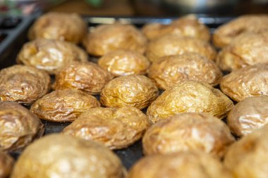 Fırından çıkarılmış kabuklu sıcak patates tabağı. Seçici odak, makro fotoğrafçılık