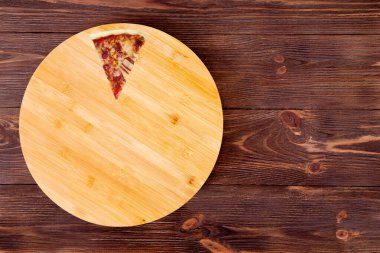 Ahşap bir tabakta jambon, bbq sosu, domuz pastırması ve salam ile bir dilim lezzetli barbekü pizza, ahşap kırsal masa, üst görünüm ve uzay kopyalama