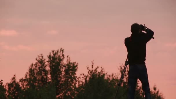 Kamerzysta fotografowania zachód słońca niebo — Wideo stockowe