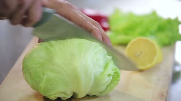 Кавказский шеф-повар отбивает айсбергский салат — стоковое видео