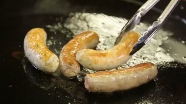 Şef tavuk ev sosis Restoran slowmotion bir tavada pişirir