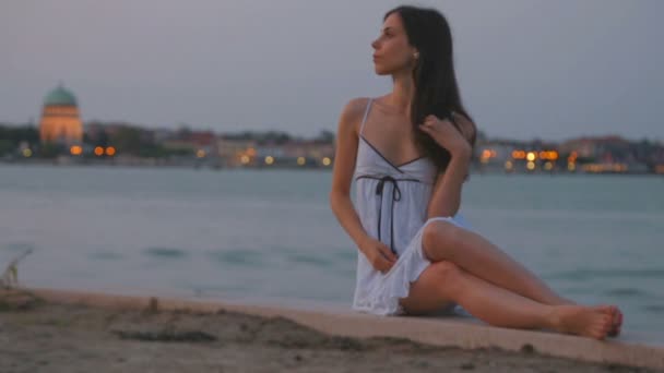 Bela jovem morena caucasiana em sexy branco verão sarafan sundress toque jogando seu cabelo escuro no fundo da água sol paisagem nascente em Veneza Itália — Vídeo de Stock