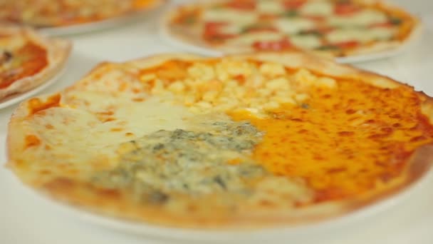 Presentatie van de pizza. Panorama van de schuifregelaar van vier kazen pizza te grillig. — Stockvideo