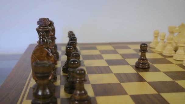 Le jeu d'échecs commence. Le pion noir ouvre la fête aux échecs, en utilisant le droit de premier mouvement. Vol circulaire, caméra de curseur de poupée — Video