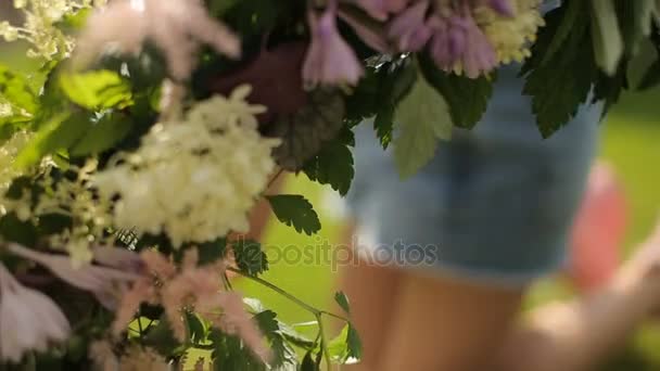 Teen european girl making a tender floral composition from pink and white flowers on a joyful summer day — Stock Video