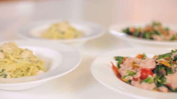 Présentation et service de plats, salade colorée fraîche avec roquette fraîche et tomates, bacon et croûtons, spaghettis et délicieux gâteau pour le dessert — Video