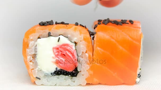 Chef luxury sushi rolls japan cuisine restaurant presentation slowmotion on white black sesame seeds falling — Stock Video