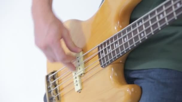 Basszus gitár játékos ujjai a húrok közelről elszigetelt fehér — Stock videók
