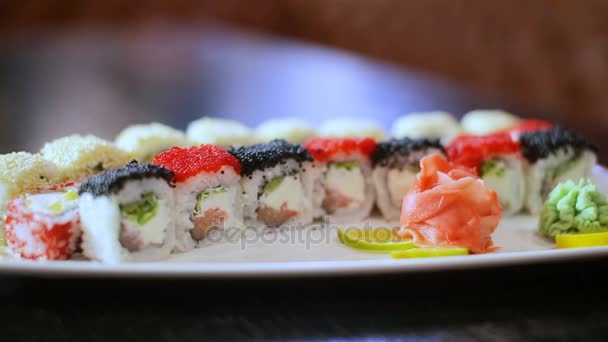 Sushi schotel op zwarte tafel in beweging rolt presentatie instellen — Stockvideo