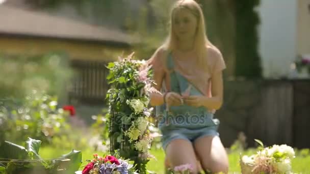 Летние солнечные блестящие воспоминания праздников - девочка-подросток улыбается наслаждаясь цветами украшения в зеленом саду магии травы — стоковое видео