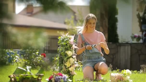 Impresionante rústico recepción decoraciones joven modelo caucásico posando haciendo una tierna composición floral en los niños actividades extracurriculares cursos floristik — Vídeos de Stock