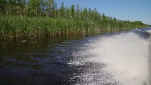 Motorový člun voda probudit vlny a pohled na břeh řeky — Stock video