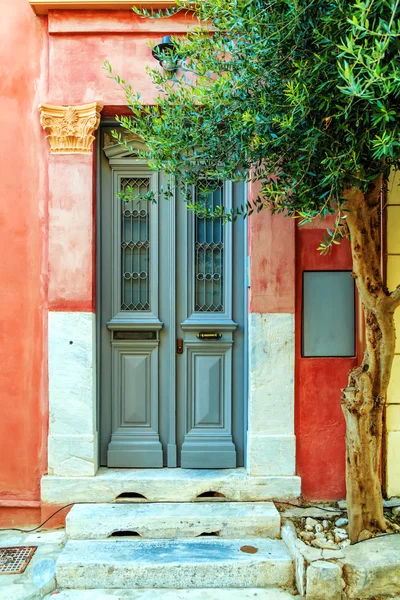 Porta da frente cinza de madeira em uma casa velha vermelha com colunas de decoração. Tiro vertical — Fotografia de Stock